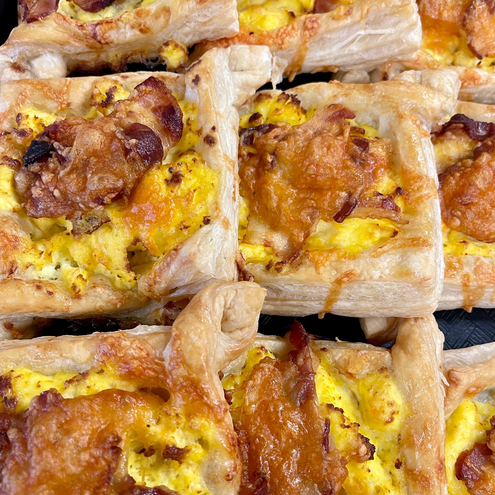 Golden bacon and egg puff-pastry squares baked fresh at Mama G's SRQ in Sarasota
