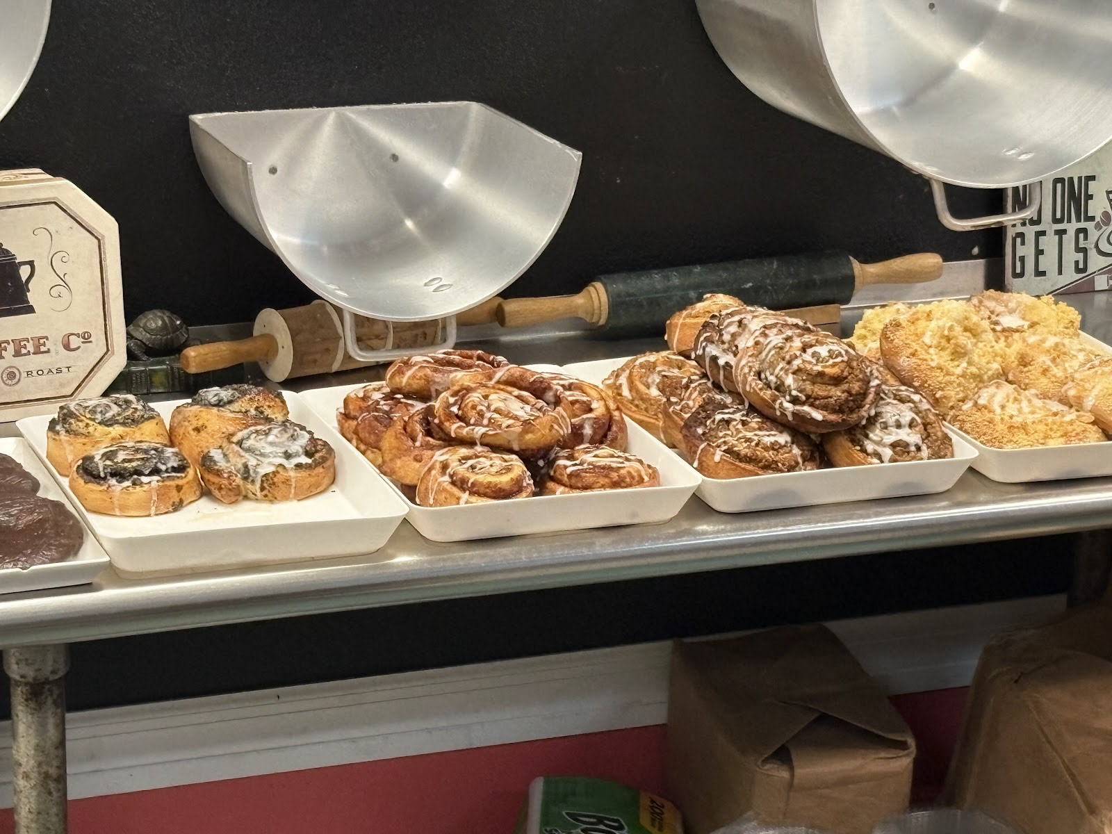 A tray of fresh cinnamon rolls and sweet pastries on the bakery counter