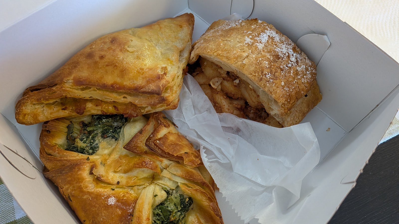 Apple strudel, spinach feta pockets and pastries in a bakery box